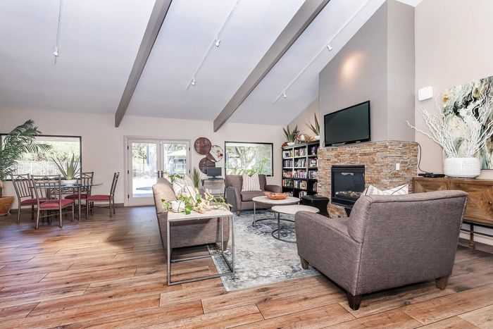 Inviting open-concept living area with stylish decor, cozy fireplace, and abundant natural light.