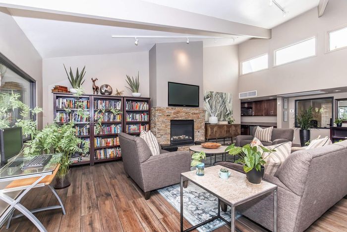 Inviting modern living room with cozy seating, stylish fireplace, and lush greenery, perfect for relaxation and entertainment.