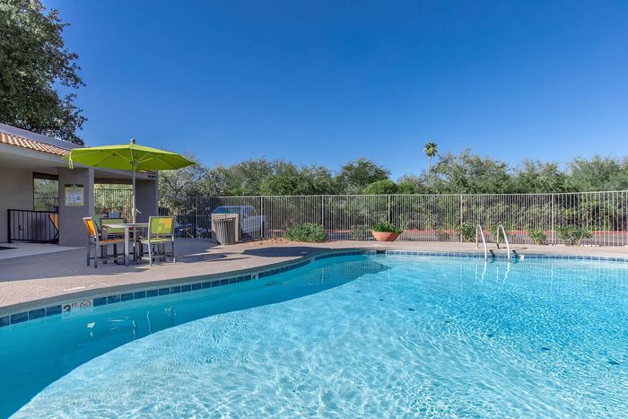 Inviting outdoor swimming pool with crystal-clear water, surrounded by lush greenery, perfect for relaxation and leisure.