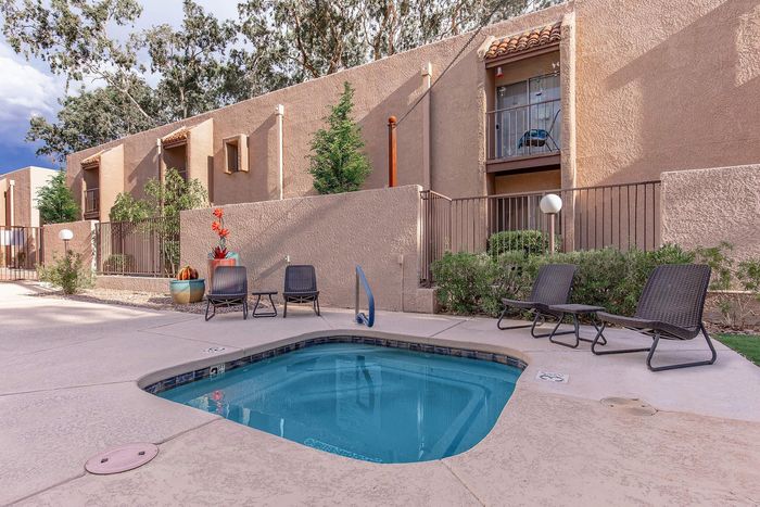 Charming apartment complex with stylish terrace and a serene outdoor pool area, perfect for relaxation and leisure.