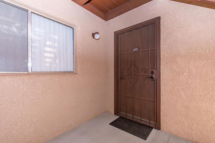 Inviting apartment entrance featuring a decorative brown security door with welcoming mat.