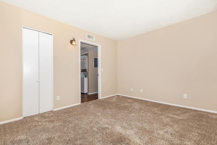 Inviting bedroom space with plush carpet, neutral walls, and a cozy closet, perfect for creating your dream retreat.