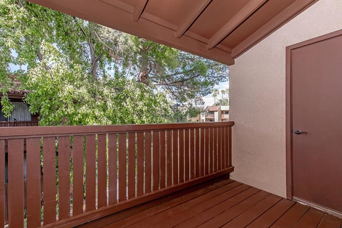 Charming apartment balcony surrounded by lush greenery, offering a serene and relaxing outdoor space.
