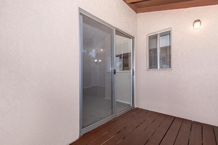 Cozy apartment patio with elegant sliding glass door and private outdoor space.