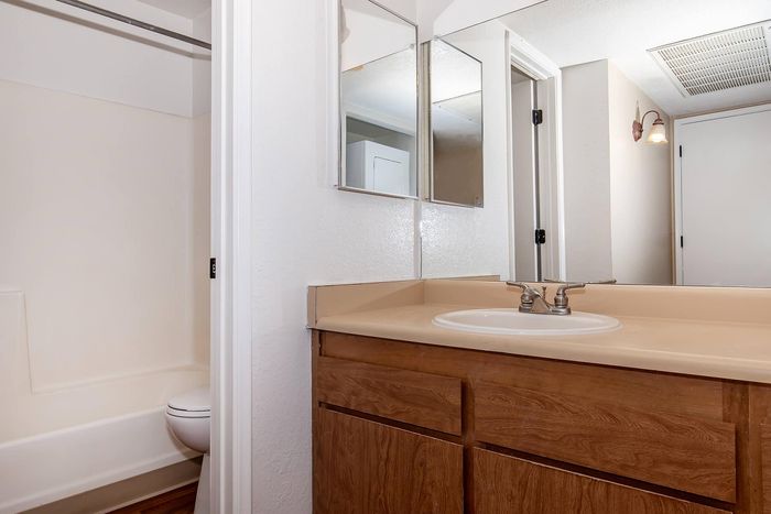 Bright and inviting bathroom featuring modern fixtures, spacious vanity with ample storage, and elegant lighting.