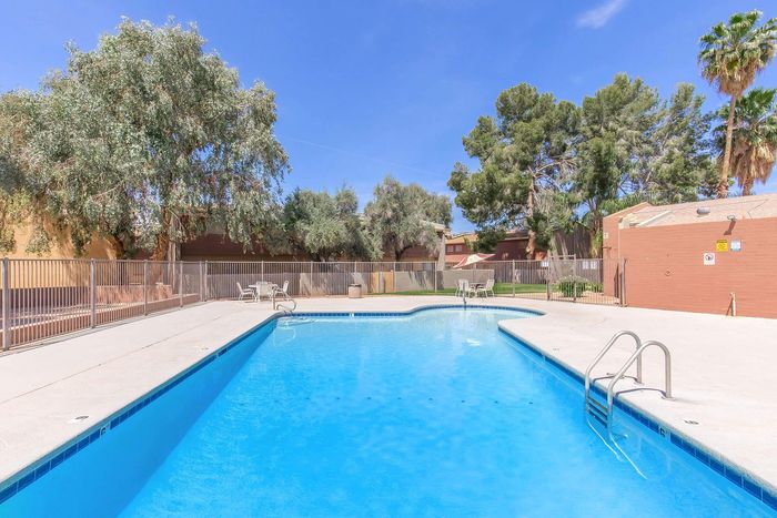 Inviting outdoor pool area surrounded by lush greenery and comfortable seating, perfect for relaxation and leisure.