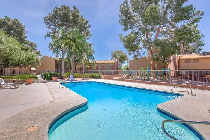 Inviting outdoor swimming pool surrounded by lush greenery and comfortable lounge chairs, perfect for relaxation and enjoyment.