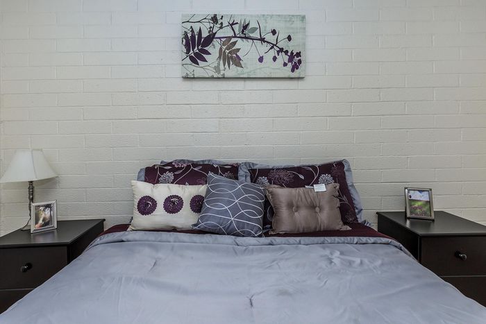 Inviting bedroom with plush pillows and elegant wall art, showcasing a cozy and tranquil ambiance.
