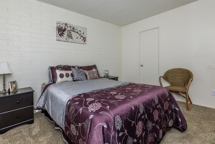 Cozy bedroom with stylish floral bedding, warm lighting, and elegant decor creating a serene atmosphere.