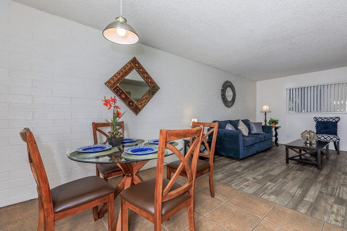Inviting living and dining area featuring elegant decor, warm wooden furniture, and modern lighting, perfect for cozy gatherings.