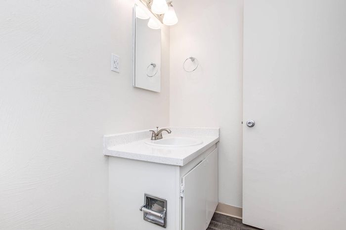 Bright and modern bathroom with sleek vanity, elegant countertop, and stylish lighting.