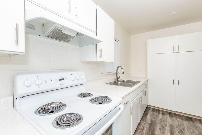 Bright, contemporary kitchen with sleek white cabinetry, modern stove, and durable countertops.