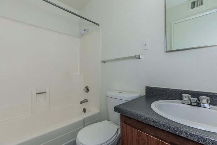 Modern bathroom featuring a sleek bathtub, elegant countertop, and stylish mirror.