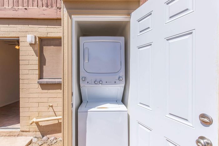 Convenient in-unit laundry with stacked washer and dryer in cozy outdoor alcove, enhancing modern living.
