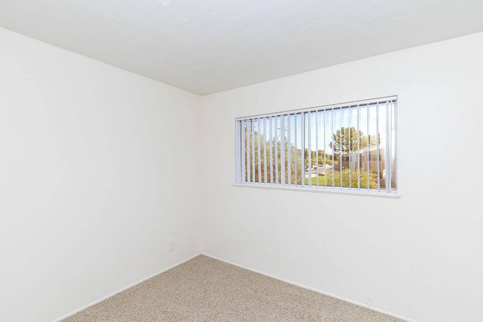 Bright, clean room with a large window offering a scenic view, perfect for creating a cozy living space.