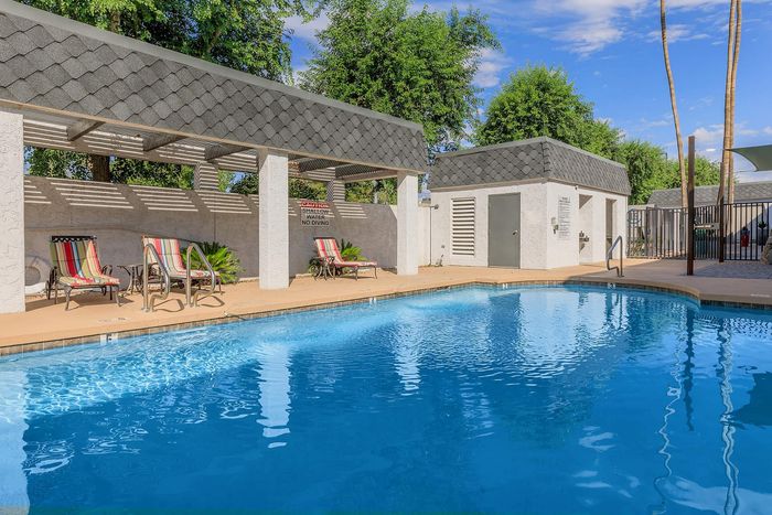 Inviting outdoor pool area with stylish seating, lush greenery, and a relaxed ambiance perfect for leisure.