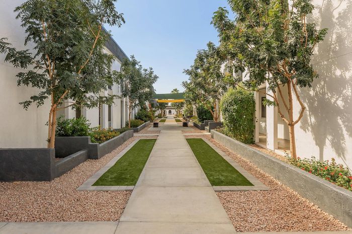 Charming apartment courtyard lined with lush greenery and inviting pathways, perfect for relaxation and leisurely walks.