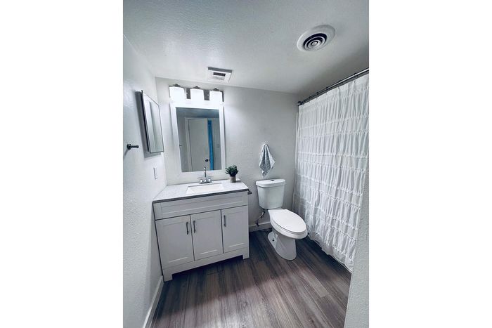 Bright and modern bathroom with elegant vanity, sleek floors, and stylish lighting, offering a refreshing space.