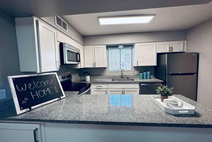 Modern kitchen with sleek granite countertops, stainless steel appliances, and charming decor welcoming you home.