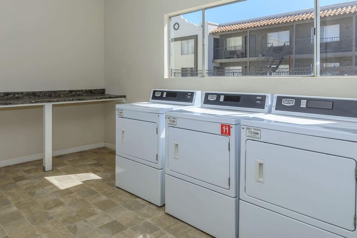 Bright and airy laundry room with modern washing machines and spacious countertops.