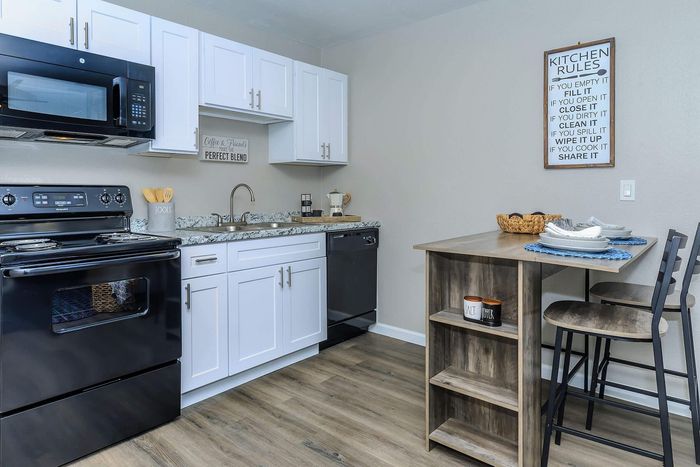 Modern kitchen with sleek black appliances, white cabinetry, and a stylish breakfast bar, perfect for casual dining.