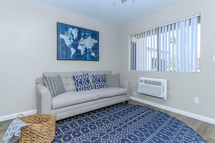 Inviting living room with a cozy cream sofa, stylish patterned pillows, and a vibrant blue world map artwork.