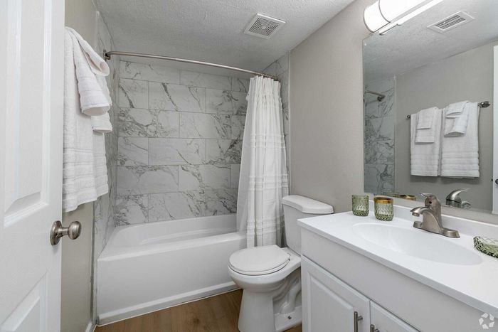 Elegant bathroom featuring marble wall tiles, stylish vanity, and a modern shower-tub combination, creating a serene oasis.
