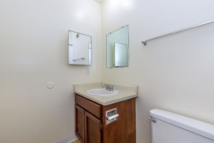 Bright bathroom with a sleek countertop sink, elegant wall mirror, and understated modern fixtures.