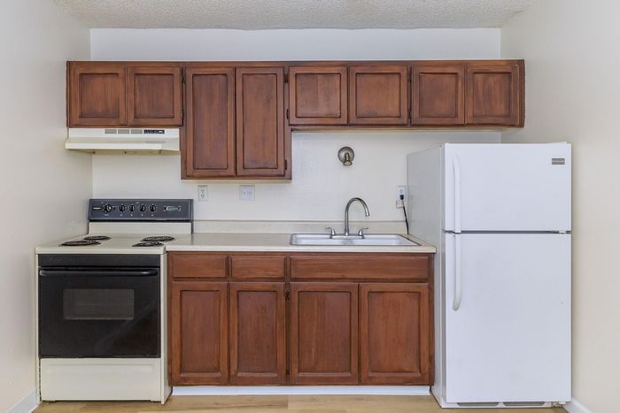Charming kitchen featuring rich wooden cabinetry, sleek countertops, and modern appliances for a cozy culinary experience.