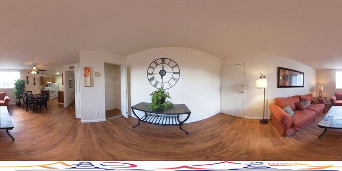 Inviting living space featuring hardwood floors, cozy seating area, and dining room adjacent to a charming kitchen.