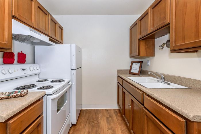 Charming kitchen with warm wooden cabinetry, sleek countertops, and modern appliances, perfect for culinary enthusiasts.