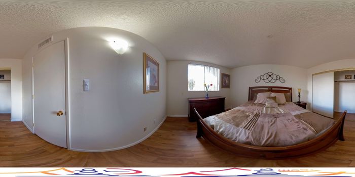 Elegant bedroom with wooden flooring, large bed, and decorative wall art, offering a cozy and inviting ambiance.