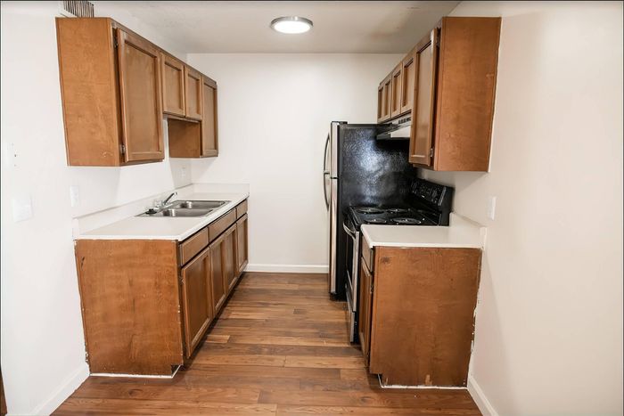 Elegant kitchen with polished wooden cabinets, sleek modern appliances, and rich hardwood floors.