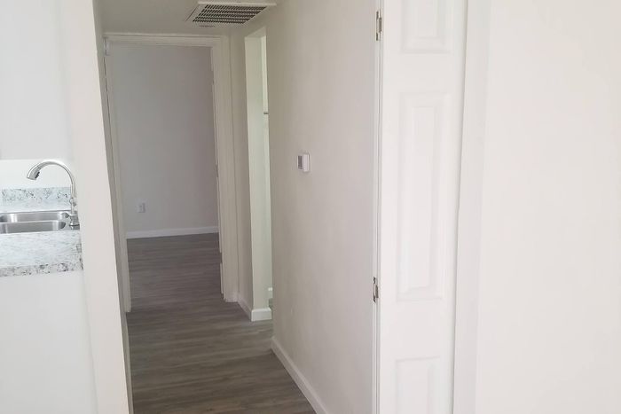 Bright hallway in modern apartment with elegant wood flooring and sleek marble countertops.