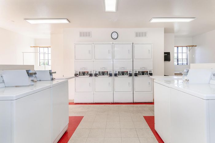 Bright and clean communal laundry room equipped with modern washers and dryers, perfect for convenient apartment living.