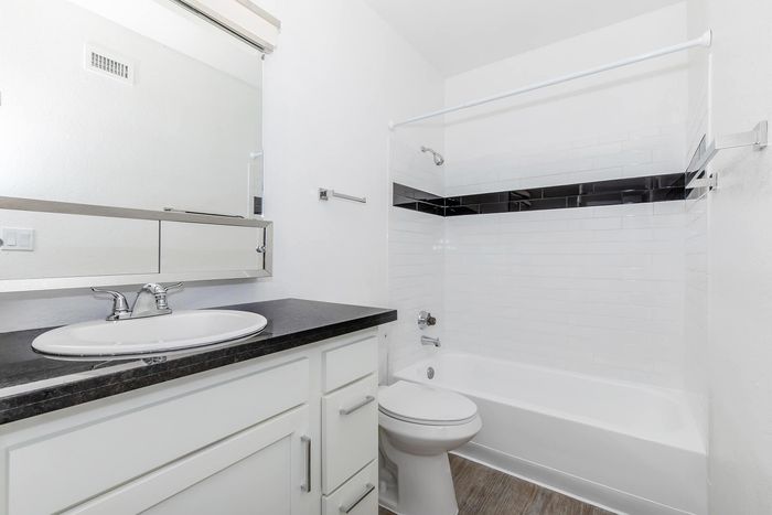Modern bathroom with sleek fixtures, elegant black-and-white tile design, and polished vanity for a refined living space.