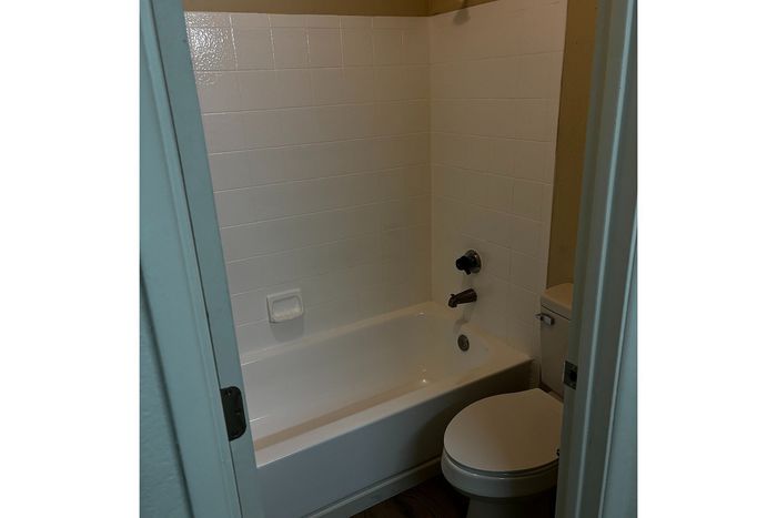 Cozy and modern bathroom featuring a pristine white bathtub and sleek fixtures, perfect for relaxation.