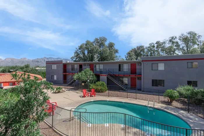 Charming apartment complex with a refreshing pool, stylish architecture, and scenic mountain backdrop.