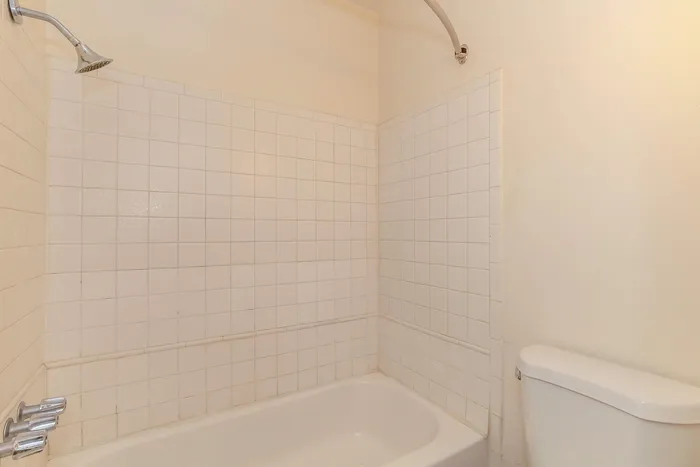 Bright and clean bathroom featuring a classic white tile shower and modern fixtures.