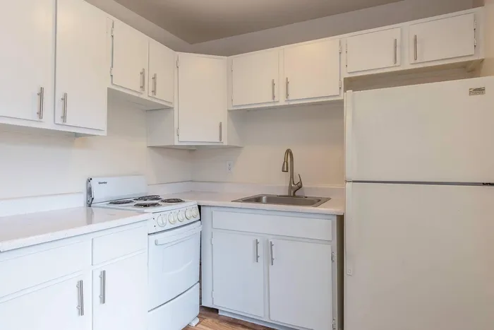Charming kitchen with sleek white cabinetry, modern appliances, and elegant countertops, perfect for gourmet cooking.