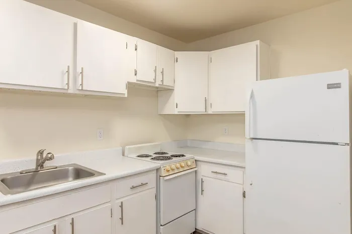 Bright and inviting kitchen with modern white cabinetry, sleek countertops, and essential appliances.