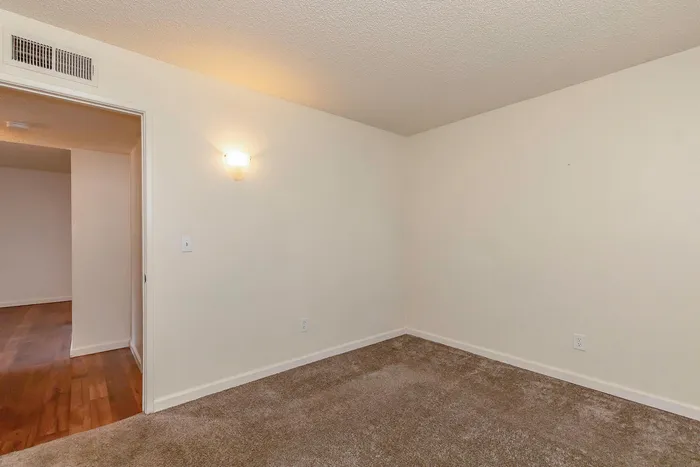 Inviting and cozy room with plush carpet and warm lighting, ideal for creating a tranquil personal space.