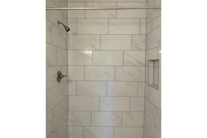 Elegant shower with sleek marble tiles and modern fixtures.