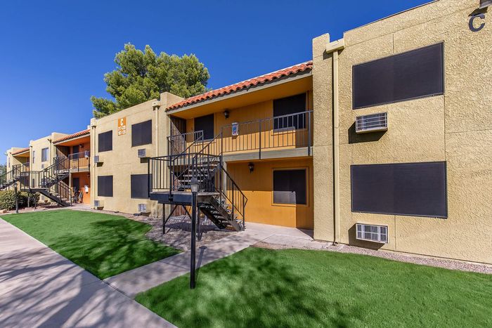 Bright, modern apartment complex with sunny yellow exteriors, charming balconies, and well-maintained landscaping.