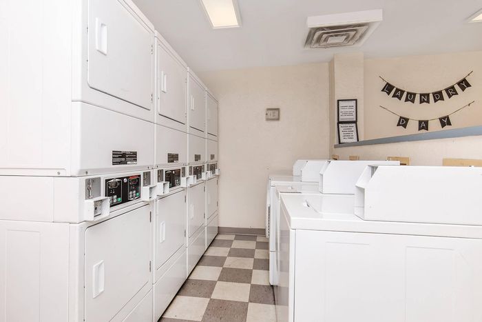 Bright and well-equipped laundry room featuring modern washing machines and dryers, perfect for convenient living.
