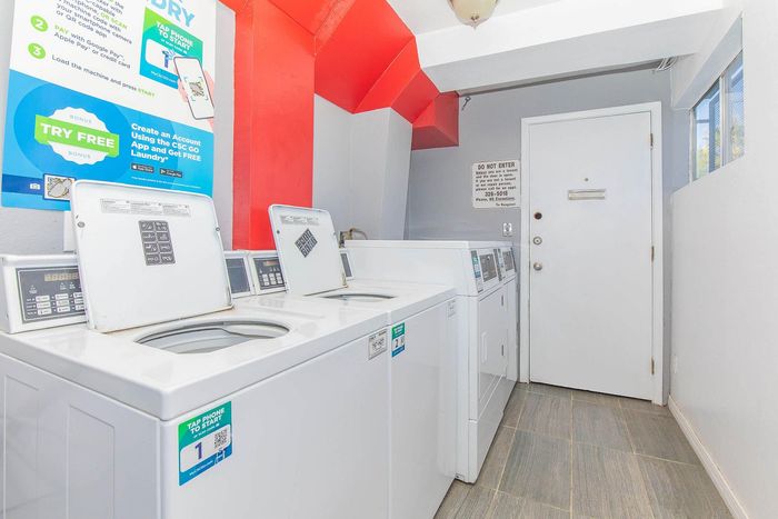 Modern laundry room featuring efficient washing machines in a bright space with distinctive red accents.
