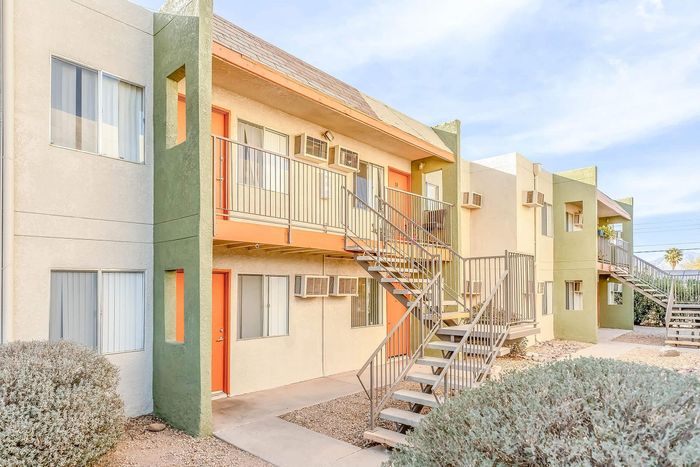 Charming apartment complex exterior featuring modern design with vibrant accents and spacious balconies.