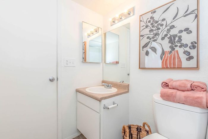 Chic bathroom featuring a stylish vanity with modern fixtures, elegant wall art, and neatly folded towels creating a fresh and inviting ambiance.
