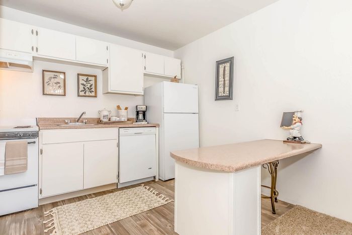 Charming, well-lit kitchen with modern appliances, elegant white cabinetry, and inviting decor.