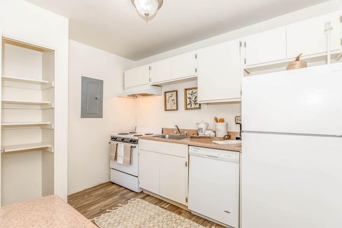 Bright, inviting kitchen with white cabinetry, modern appliances, and wood flooring, perfect for culinary creativity.
